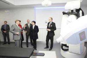Geschäftsführer des CyberKnife Centrum Mitteldeutschland Andreas Mosmann, Staatskanzleichefin Marion Walsmann, Dr. med. Hans-Ulrich Herold, leitender Arzt für Strahlentherapie, Ministerpräsidentin Christine Lieberknecht und Medizinphysiker Gunnar Surber im Behandlungsraum des CyberKnife Centrum neben dem Behandlungsroboter.